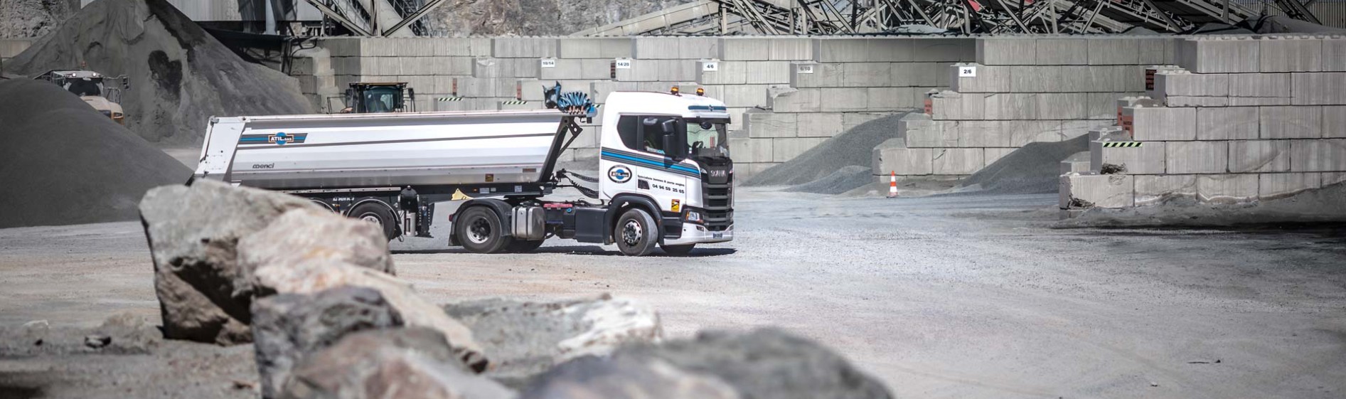 Photo d'ATIL : une semi-benne ATIL sur un site de carrière, devant des blocs de pierre
